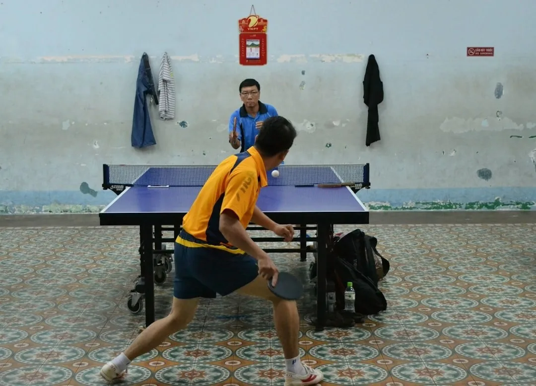 一位台灣桌球選手在室內賽事中專注發球的畫面
