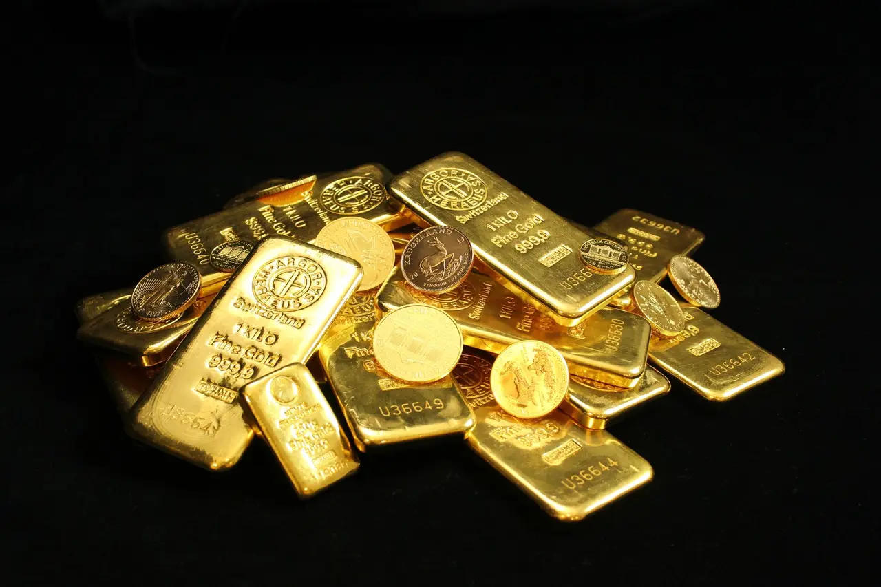 金價走勢圖與黃金實體在分析師桌面上並置，畫面中可見一段上揚與一段下滑的趨勢線