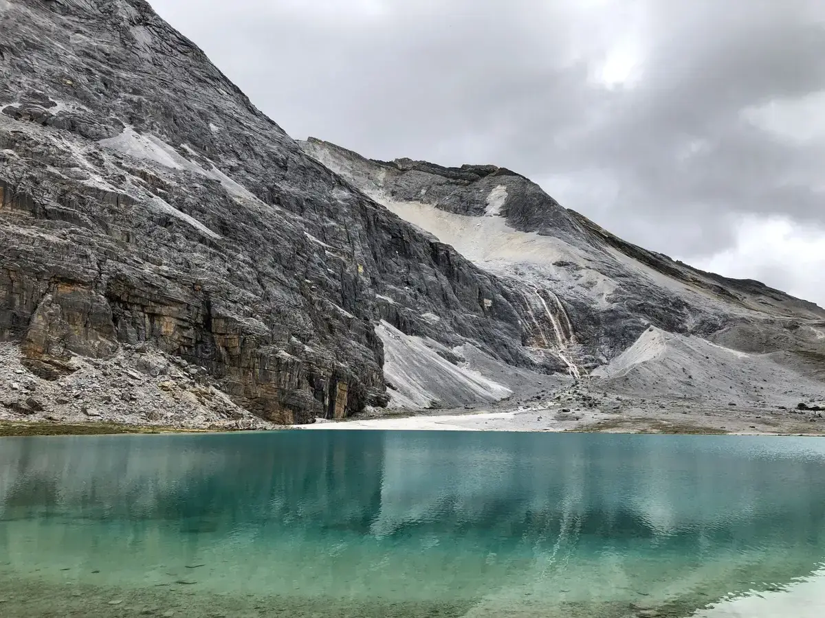 高山湖泊映著草原與山稜線的自然景觀（示意圖）