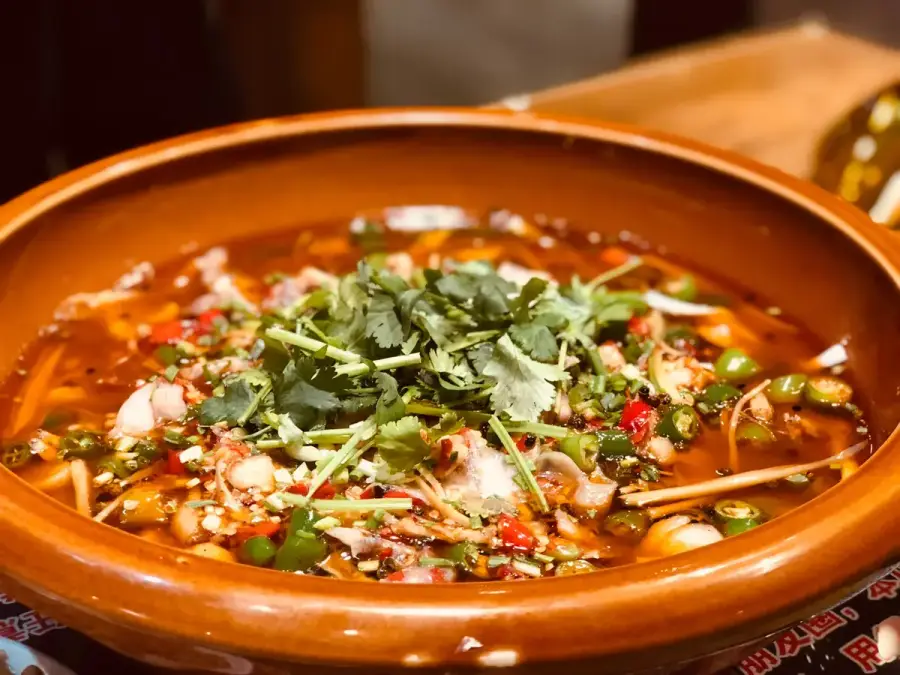 香菜鋪在火鍋湯底上的美食示意圖