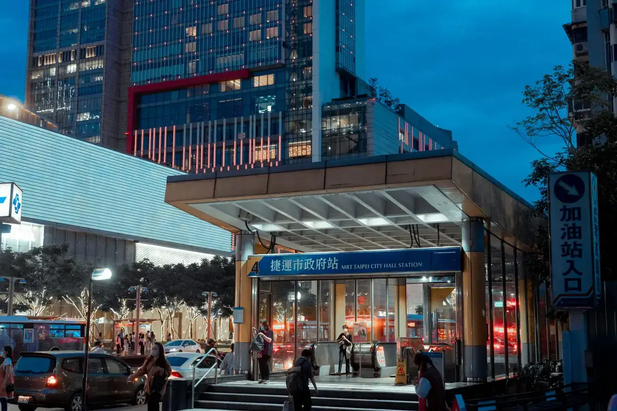 台北捷運市政府站入口與通勤人流的夜間畫面，呈現悠遊卡搭乘大眾運輸的使用情境