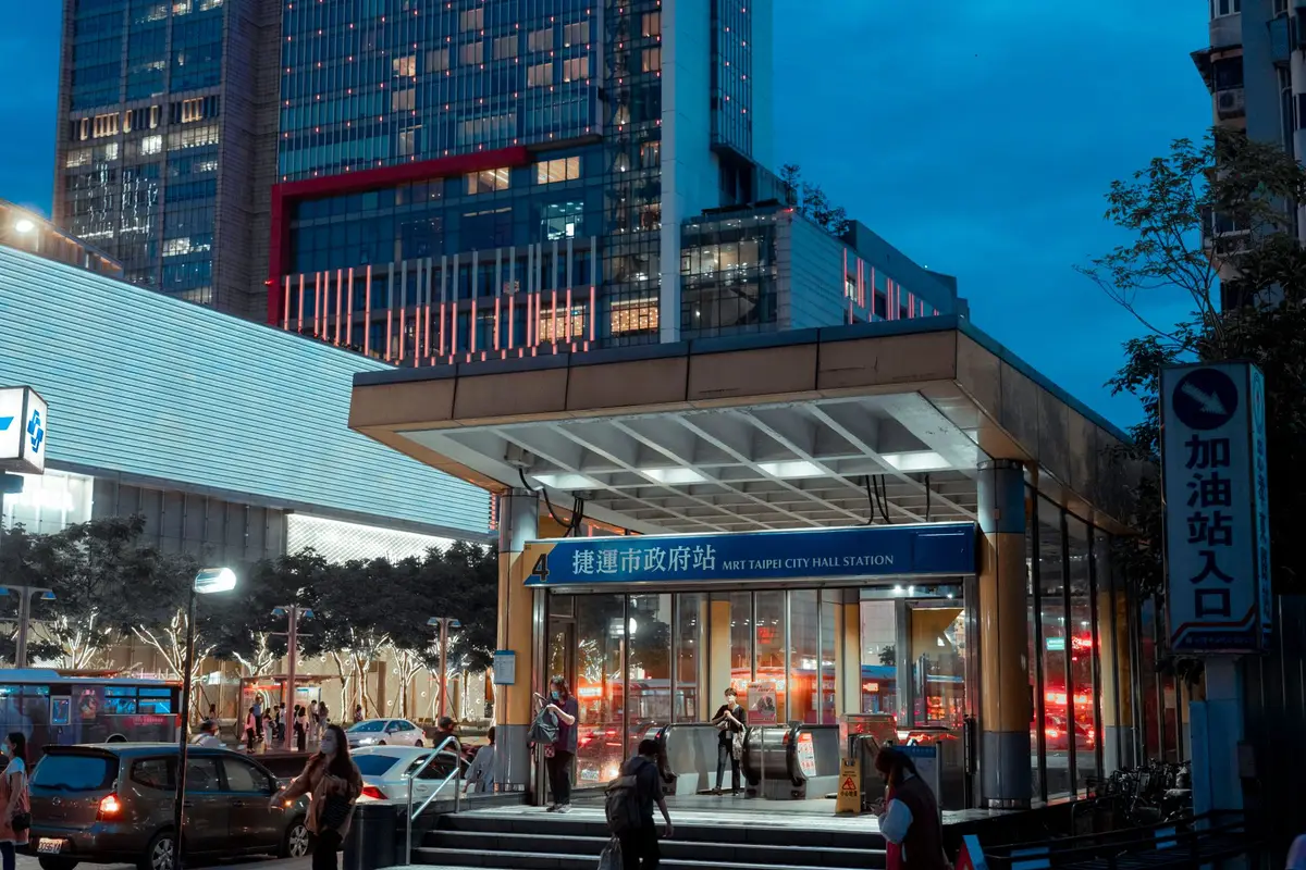 台北捷運市政府站入口與通勤人流的夜間畫面，呈現悠遊卡搭乘大眾運輸的使用情境
