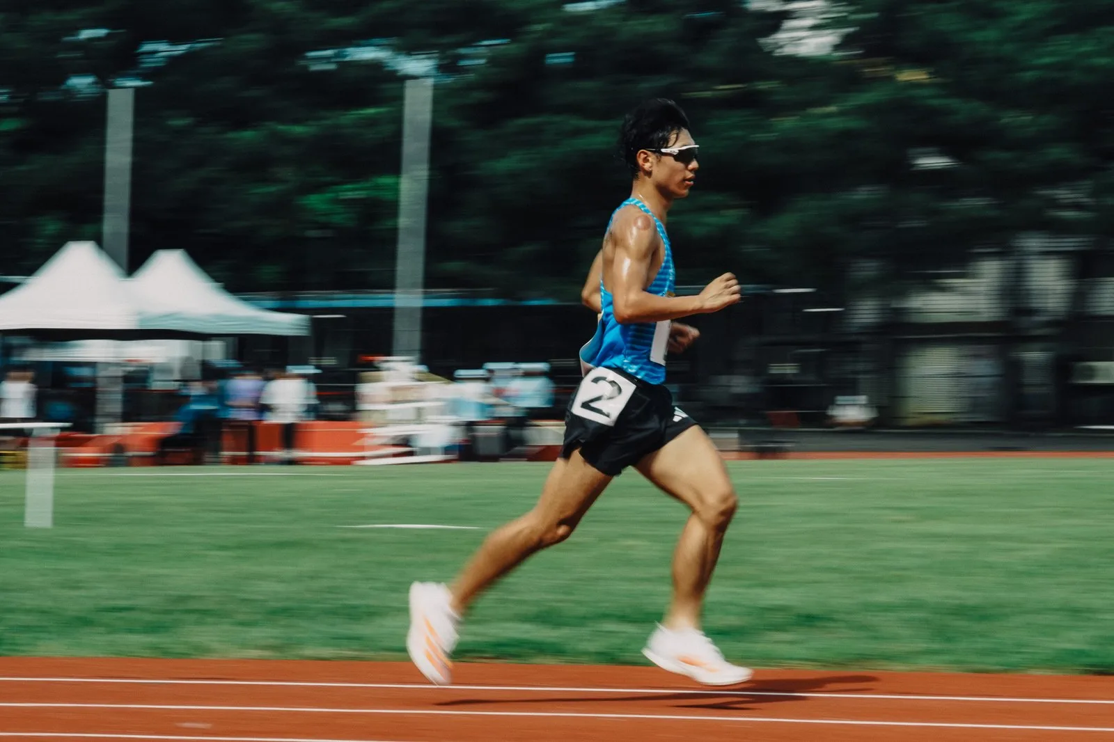 田徑場上一萬公尺決賽進行中，多名選手在跑道上競逐。
