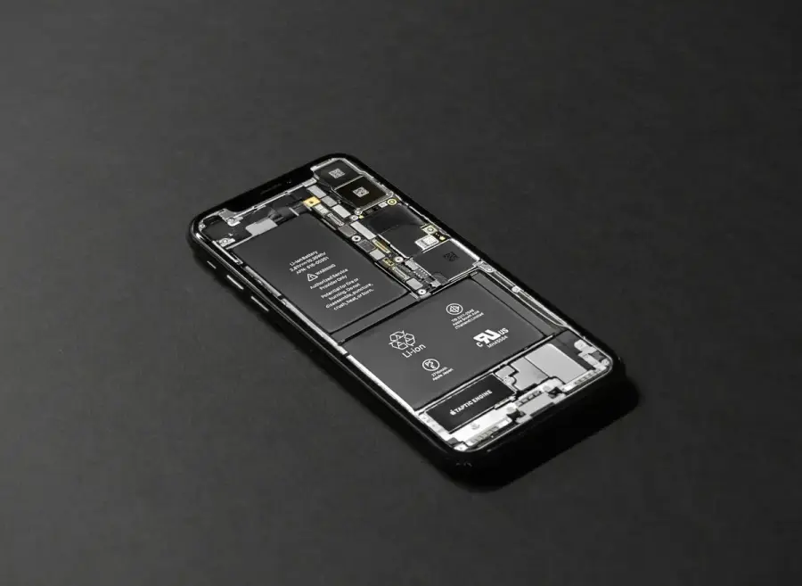 拆開的智慧型手機露出內部電池與零件，象徵換購前的電池檢查