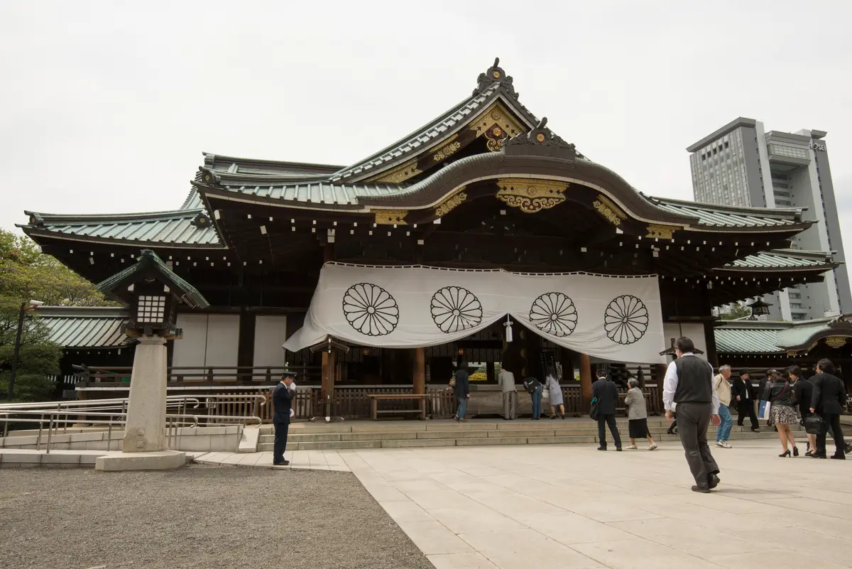 靖國神社拜殿正面，木造建築與參道石燈籠