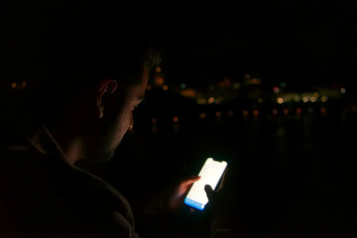 有人在夜間查看手機並處理帳號異常（示意圖）