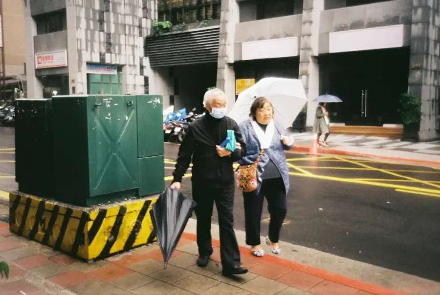 年長者在家中使用智慧照護感測設備，家屬在一旁查看手機通知