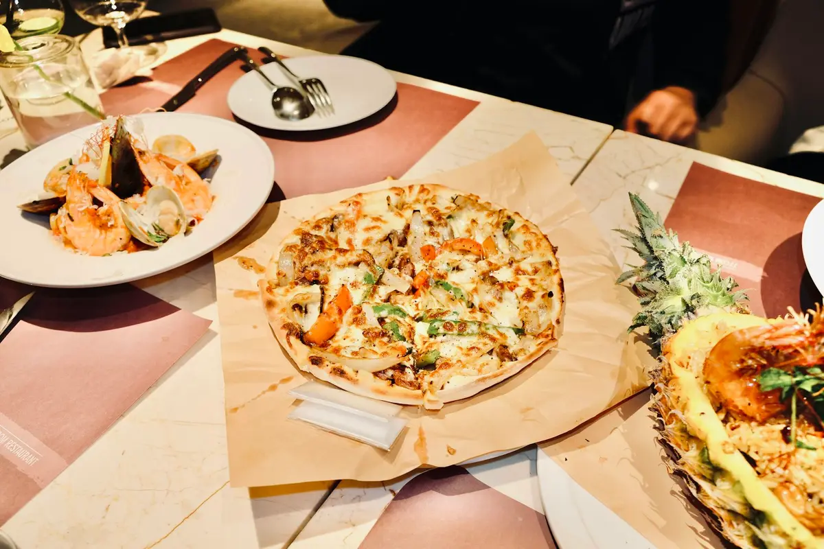 中秋聚餐餐桌上的披薩、牛排與海鮮，餐飲選擇示意圖
