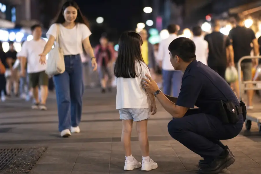 夜市中服務人員安撫走失孩童並協助與母親團聚