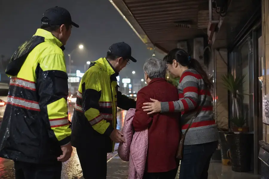豪雨夜服務人員在騎樓協助老婦與女兒團聚