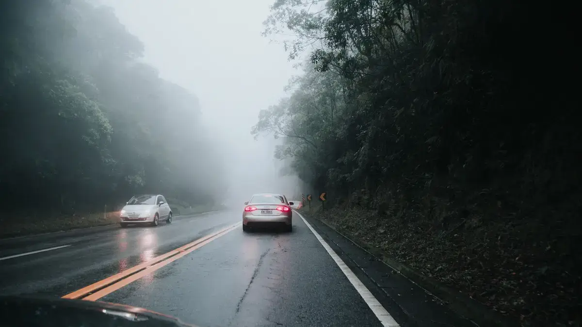 雨天道路旁停靠故障車輛的交通安全情境示意圖