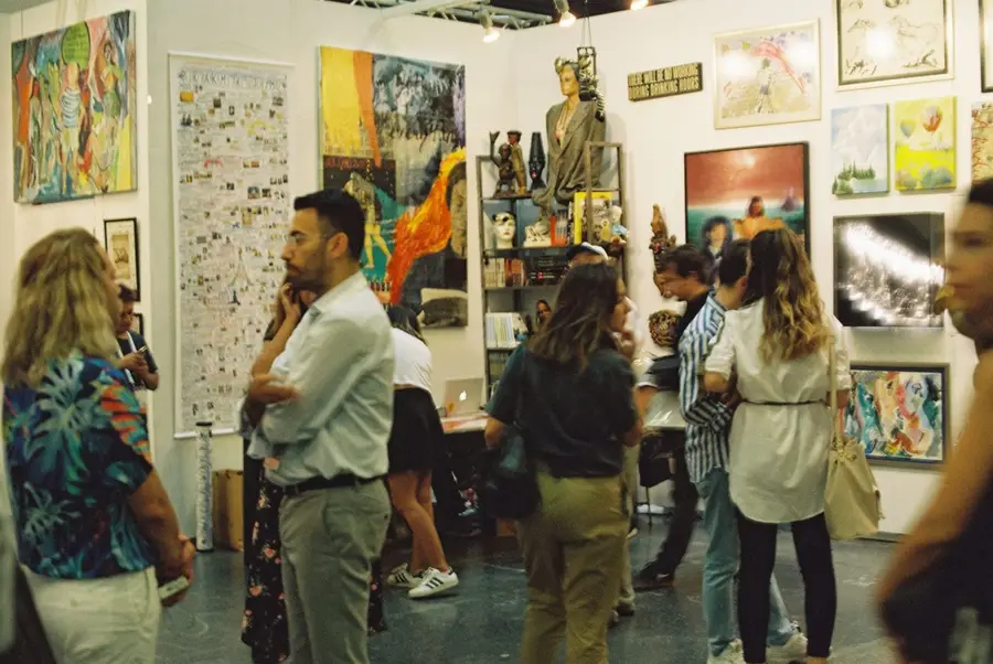 觀眾在展示多元藝術品的畫廊中欣賞作品的熱鬧場景