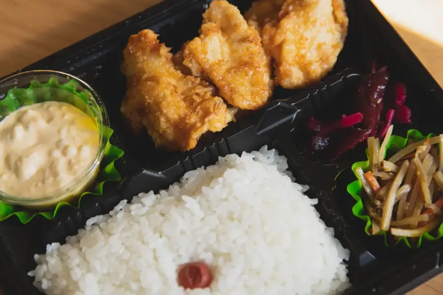 外帶便當、食品溫度計與餐桌上的供品，呈現普渡熟食保存與食品安全查證主題（示意圖）