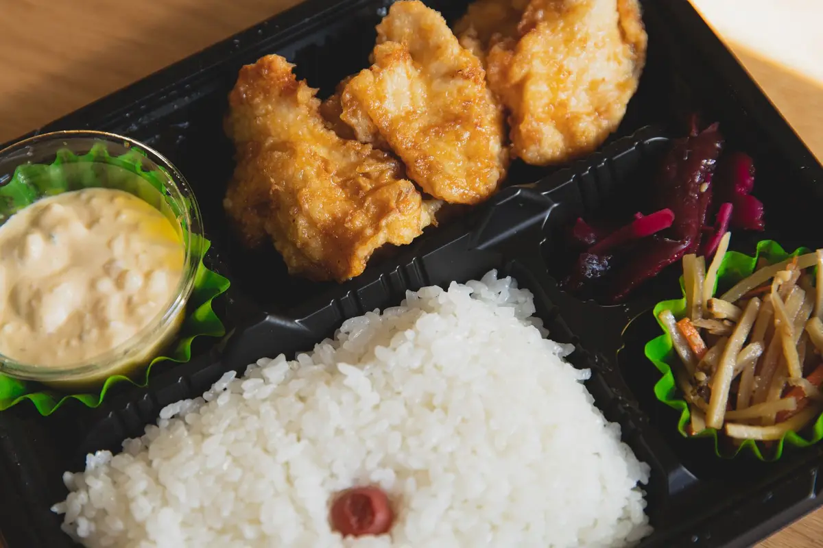 外帶便當、食品溫度計與餐桌上的供品，呈現普渡熟食保存與食品安全查證主題（示意圖）