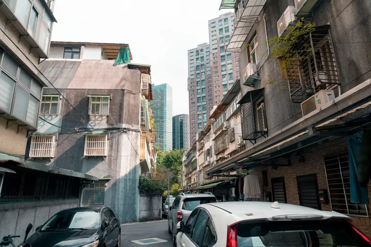台灣住宅街區與高樓住宅交錯，象徵房貸寬限期與還款負擔