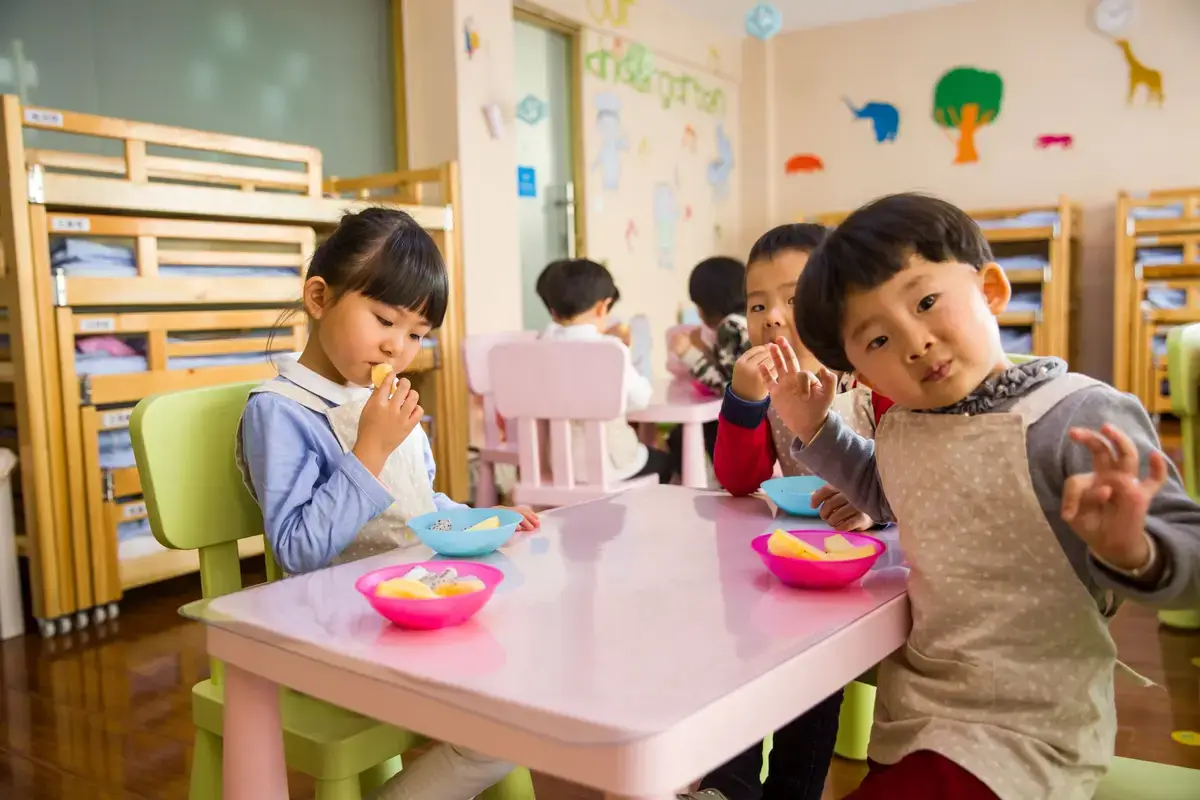 幼兒在餐桌旁飲用乳品的早餐與校園用餐情境