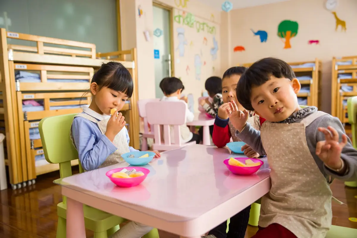 幼兒在教室餐桌用餐的校園午餐情境