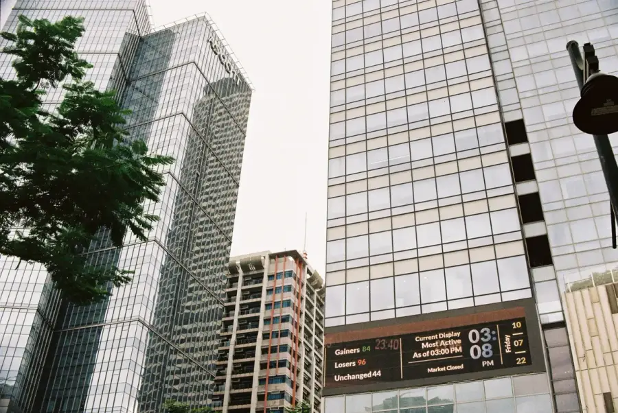 金融商業區大樓與電子股市看板，象徵AI股市榮景牽動稅收政策