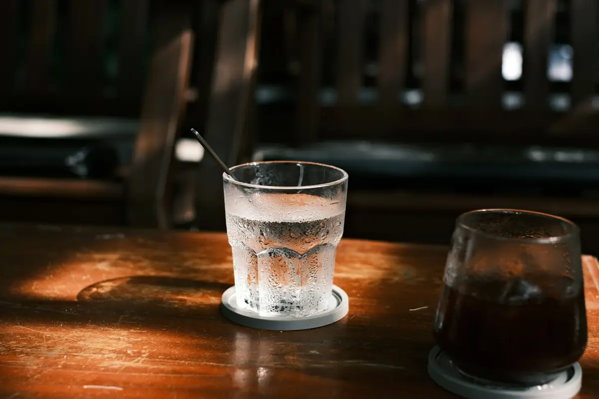 桌上放著含糖茶飲與白開水的日常飲品示意