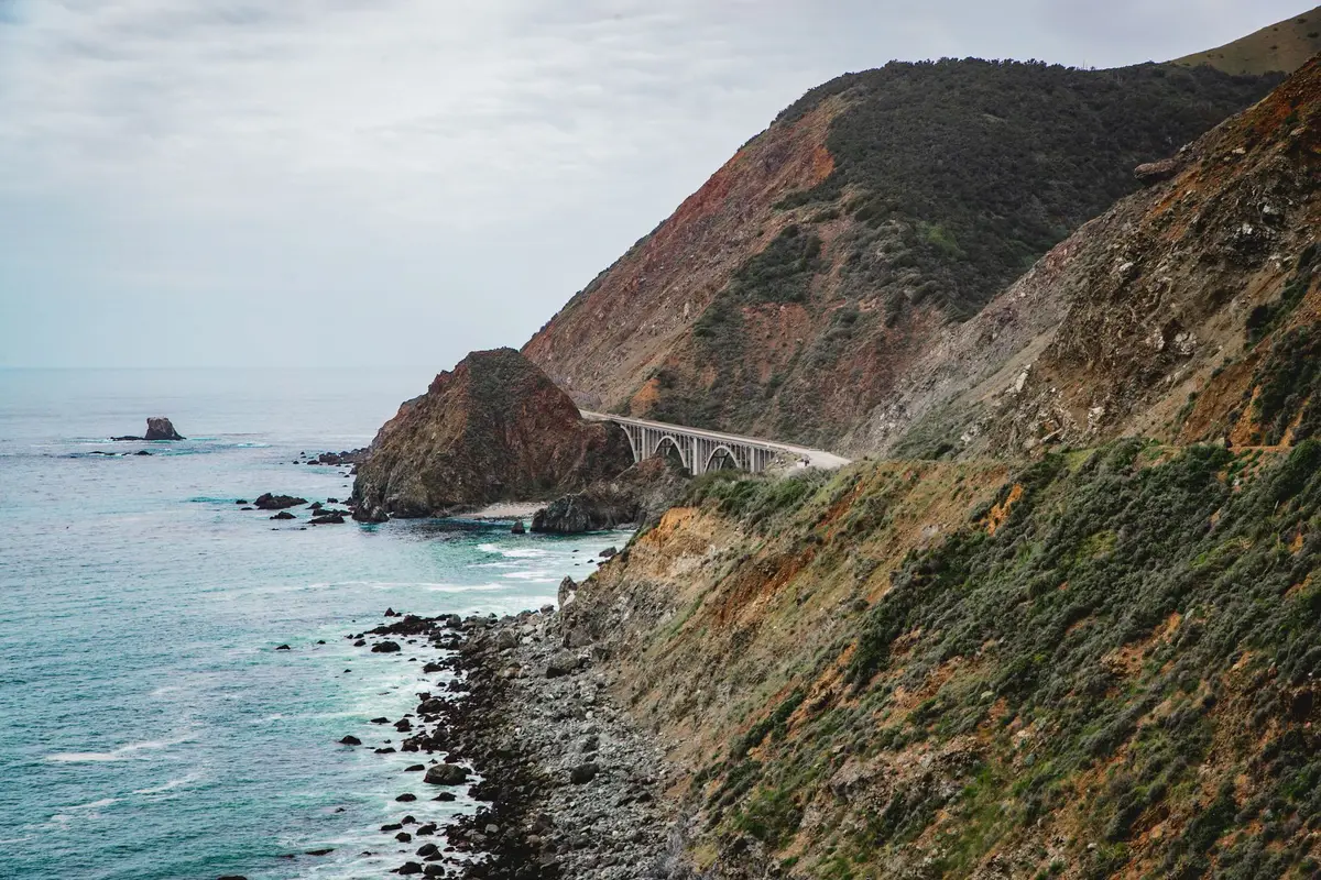 蜿蜒的濱海山區公路空拍景觀，一側緊鄰海岸