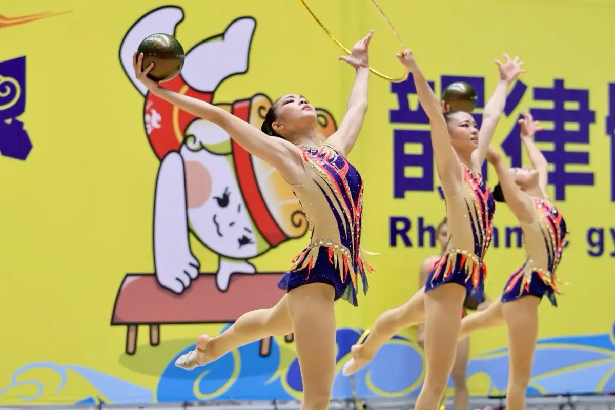 台灣女子韻律體操團隊在室內體育館同步完成團體動作與器械交換。