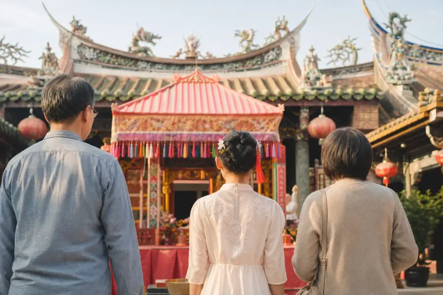 青少年與父母從背後望向台南廟宇成年禮會場的示意圖