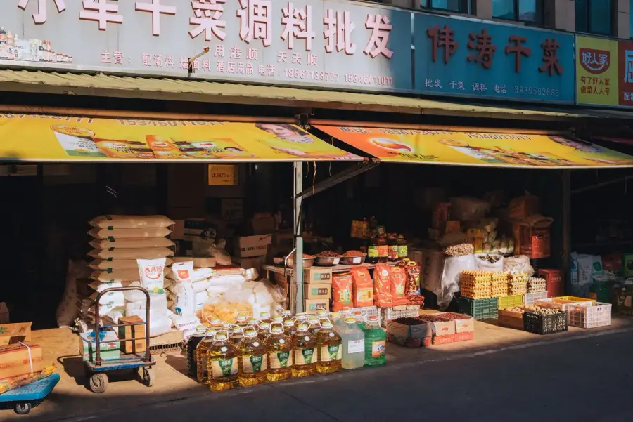 食品市場陳列米、茶葉、蜂蜜與水果等農產品，呈現消費者查看商品資訊的情境（示意圖）