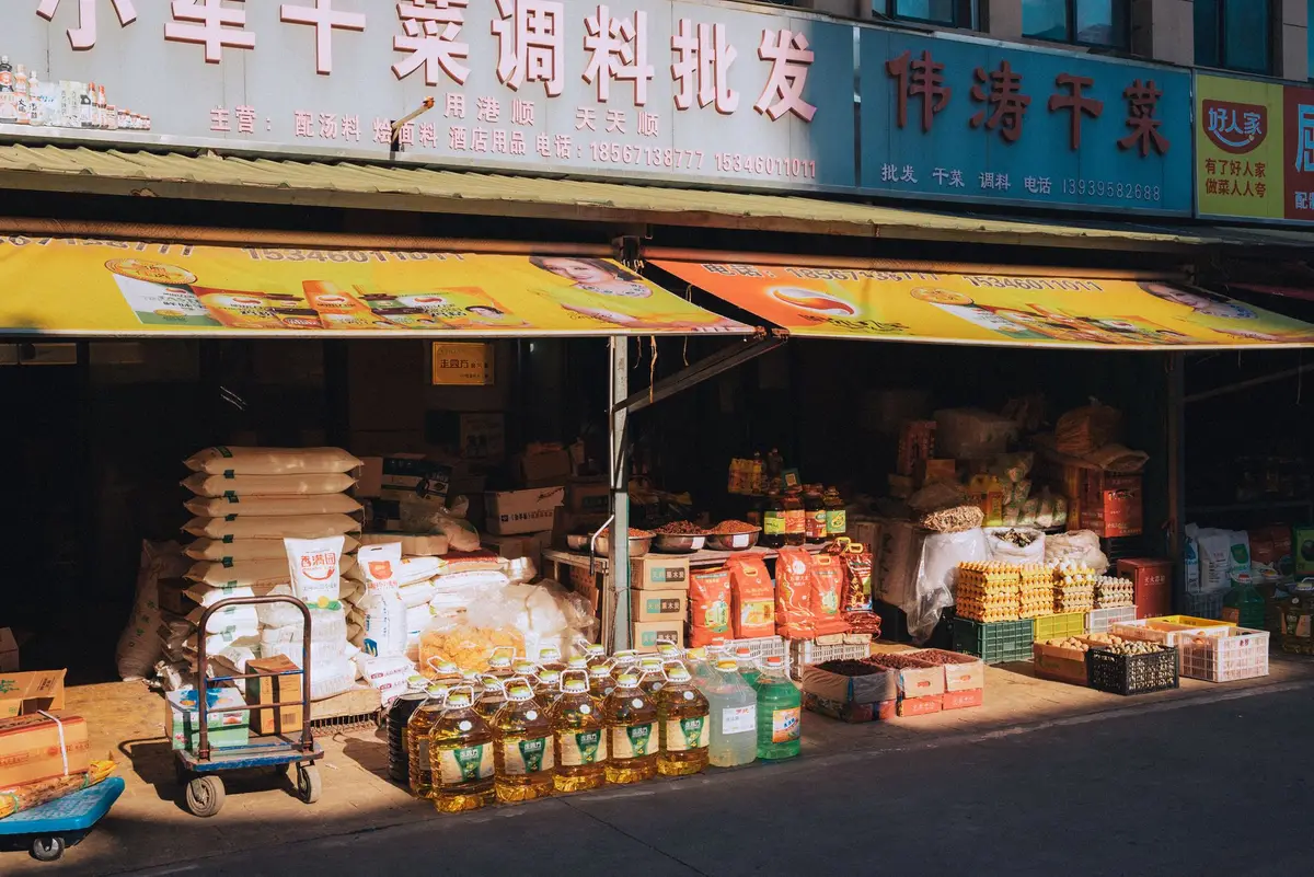 食品市場陳列米、茶葉、蜂蜜與水果等農產品，呈現消費者查看商品資訊的情境（示意圖）