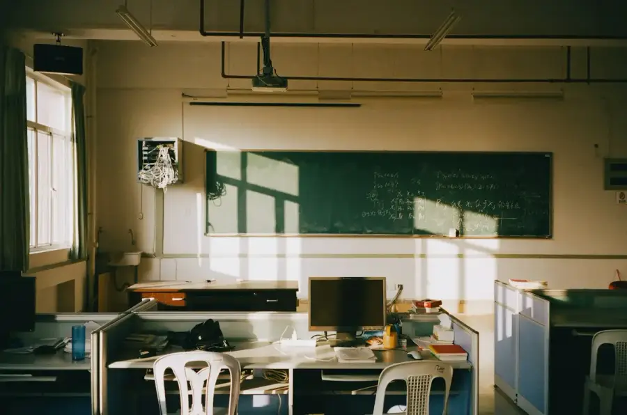 教室桌面上的校園規範文件與筆記本，背景是空教室（示意圖）