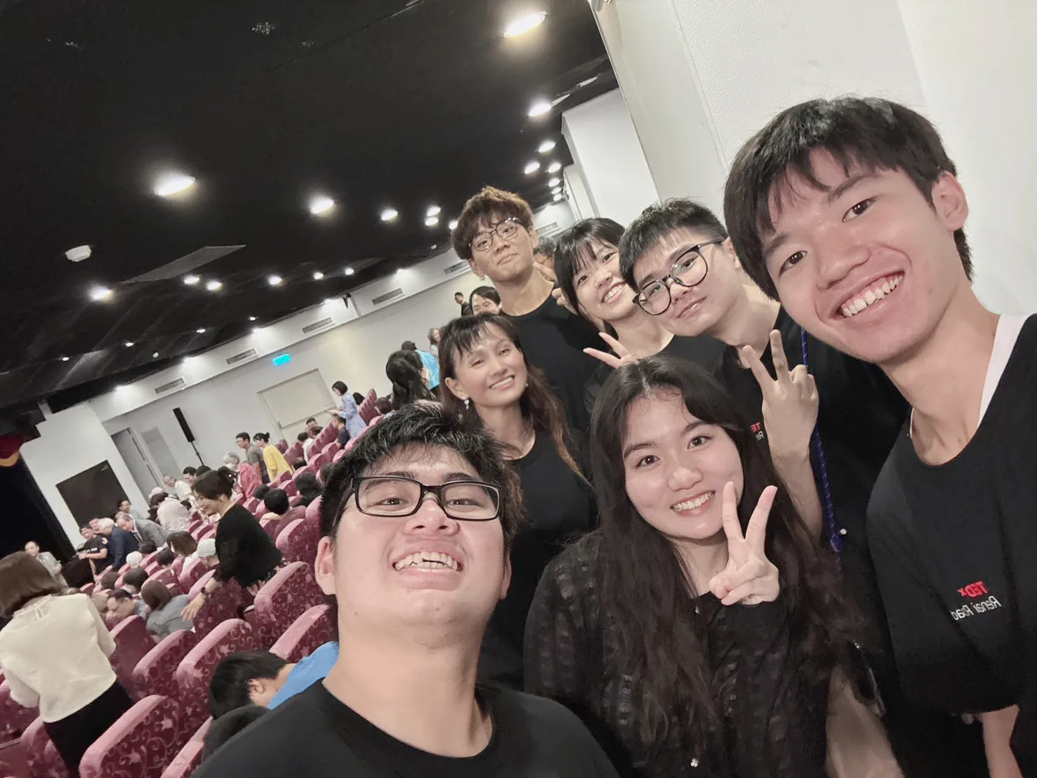 TEDxRenaiRoad志工與觀眾在演講廳內合影，呈現活動現場的團隊氣氛