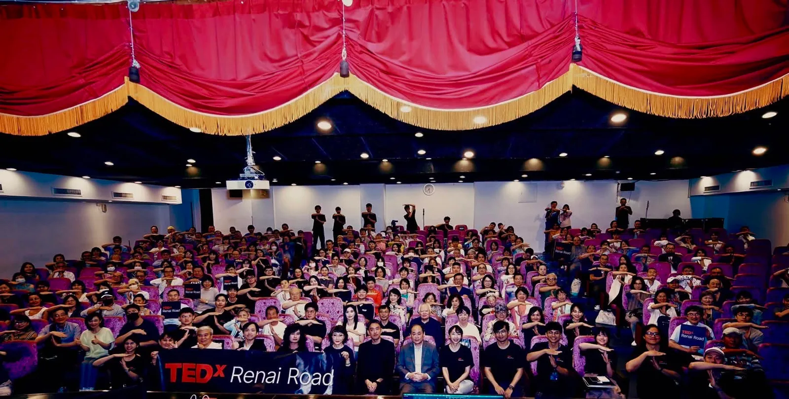 第三屆TEDxRenaiRoad現場，觀眾席滿座並一起比出呼應主題的手勢