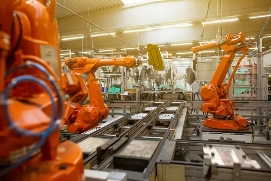 工廠內橘色工業機器手臂運作示意圖，象徵機器人科技（示意圖）