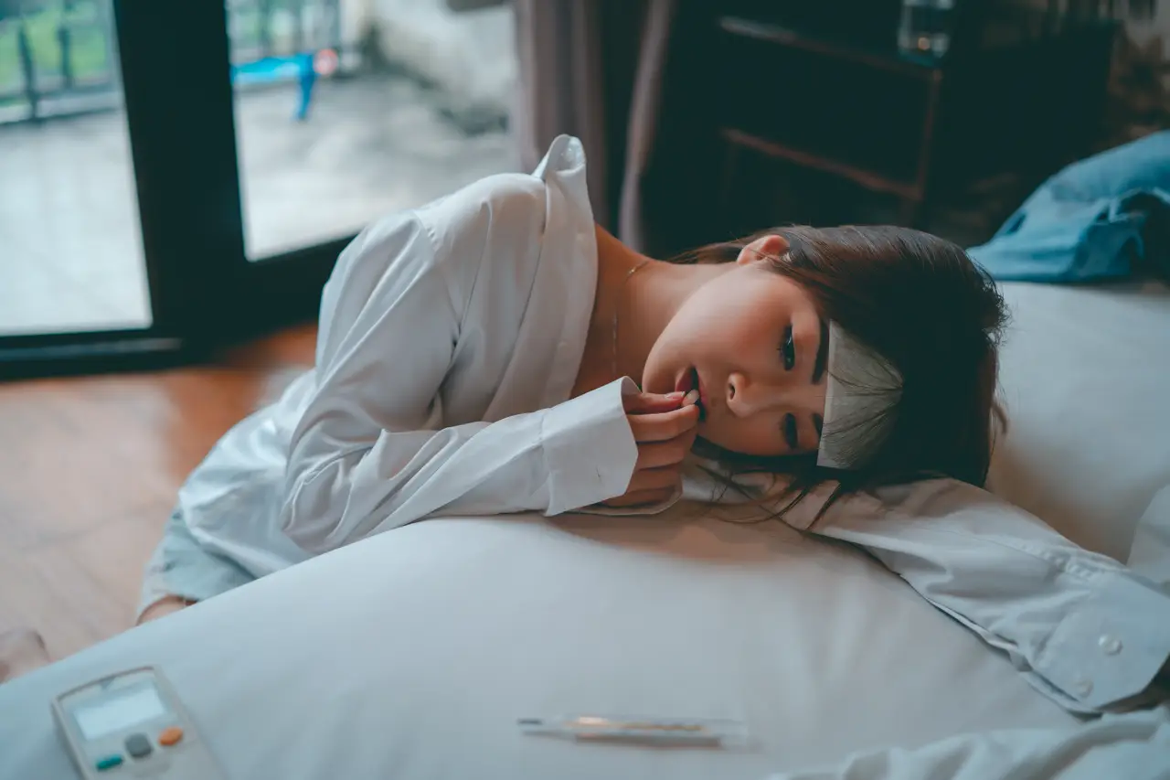 一名女性側坐沙發上抱膝，神情若有所思，反映健康焦慮的心理狀態