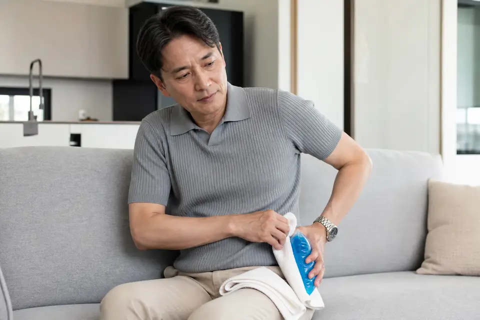 冰袋與毛巾放在髖部旁，示意冰敷前要先用毛巾隔開