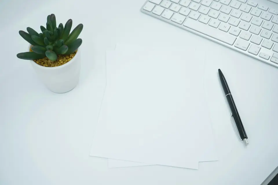 請假表單可記錄日期、天數與必要行政資訊(示意圖) 辦公桌上的空白文件、筆與鍵盤,呈現填寫特休申請資料的情境