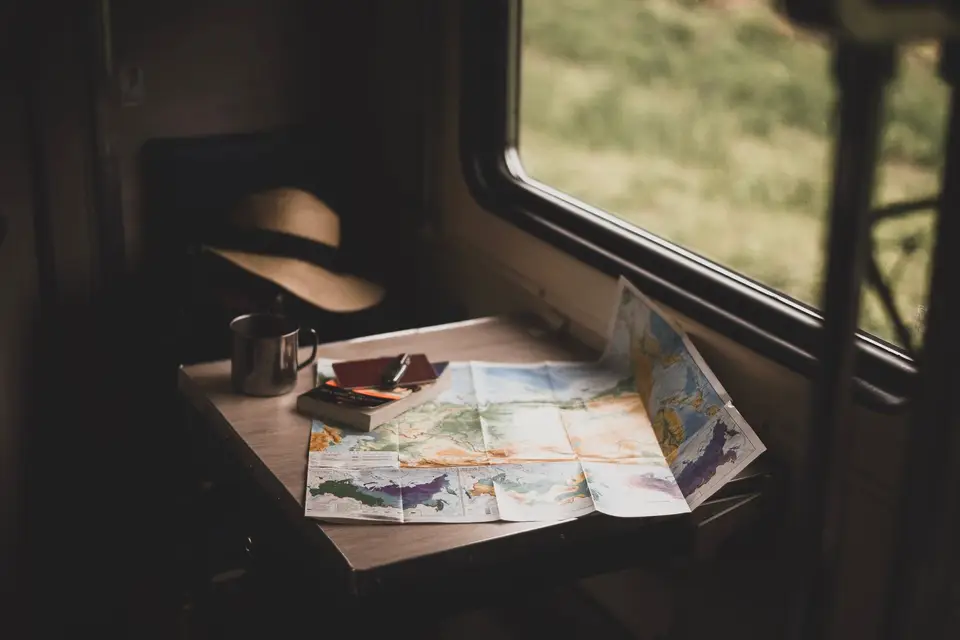 桌上攤開地圖與旅遊資料，呈現規劃海運行程的情境