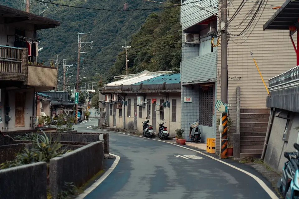 雨天的台灣山區鄉鎮道路與民宅，呈現嘉義、臺南、高雄、屏東、花蓮、臺東六縣市公告範圍