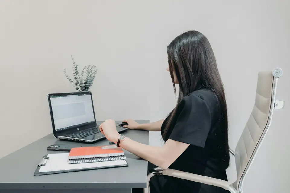 上班族用手按壓肩頸，反映久坐用筆電造成的痠痛