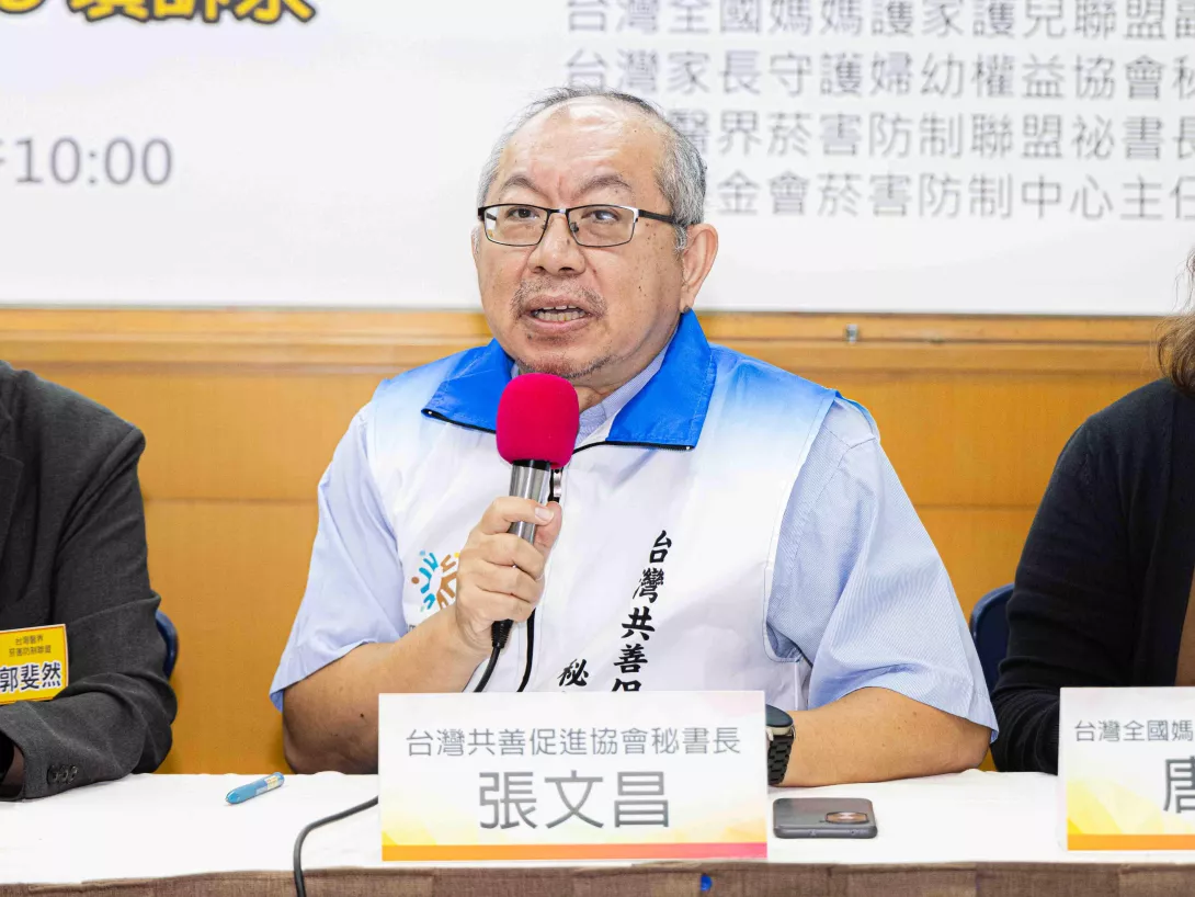 張文昌在座談中持麥克風發言，討論青少年與家庭支持