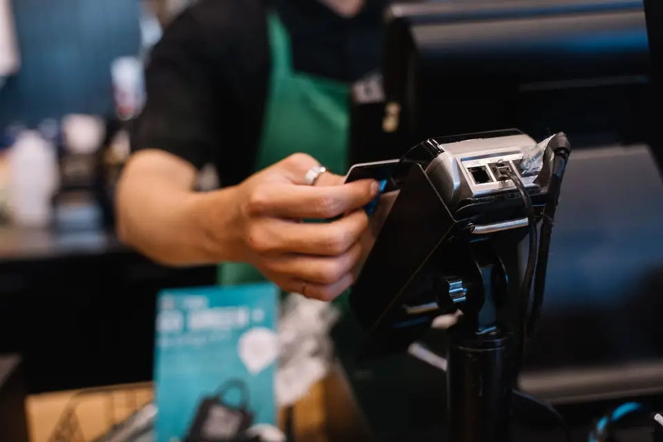咖啡店櫃檯使用感應式付款，象徵 Apple Pay 交易流程