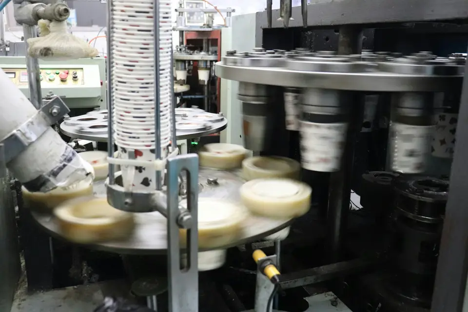 食品容器與熱封包裝設備，示意封口機將薄膜固定在杯口