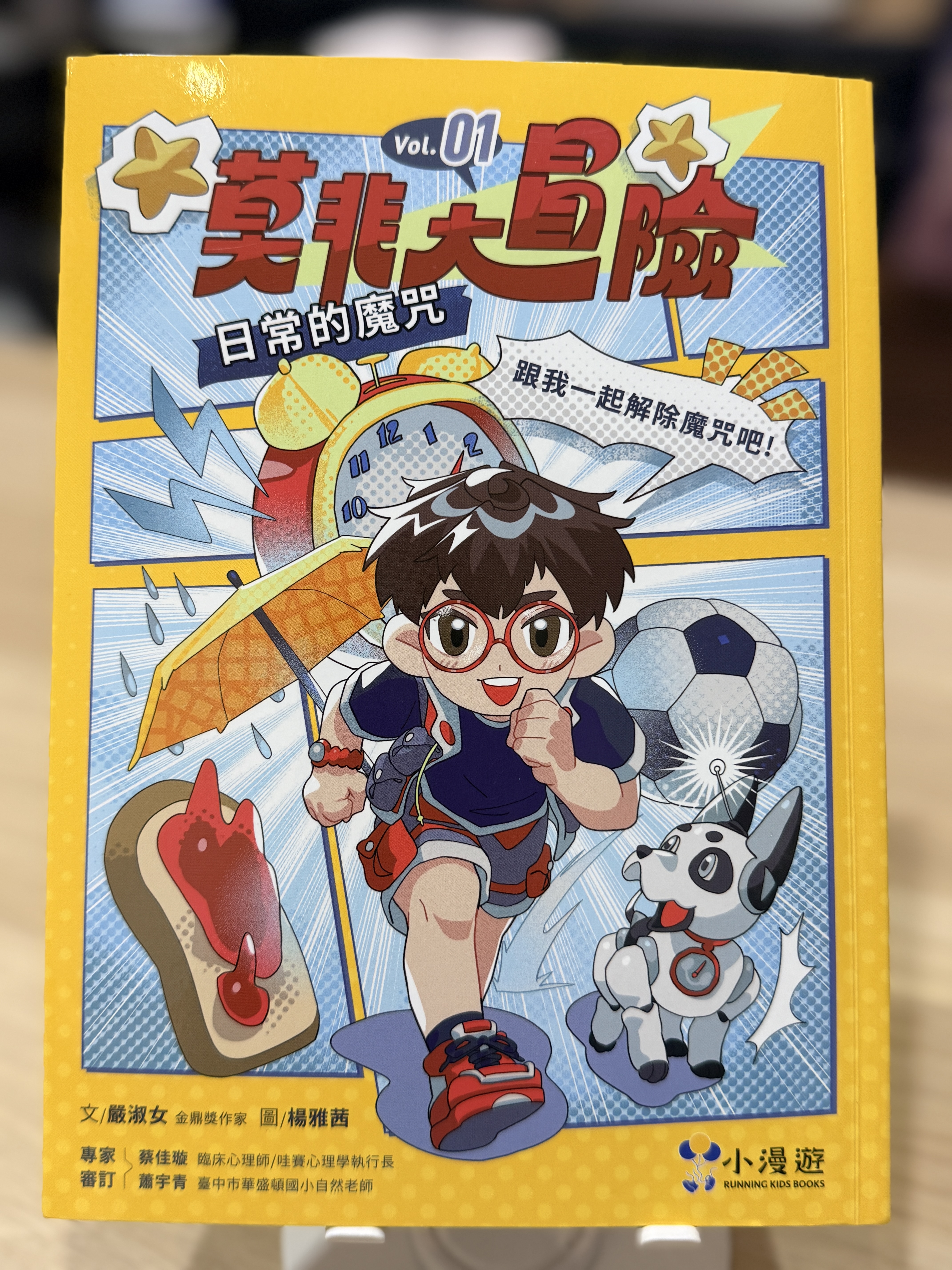 《莫非大冒險1：日常的魔咒》書封，封面呈現阿莫、AI機器狗小非，以及鬧鐘、雨傘與果醬吐司等日常魔咒元素