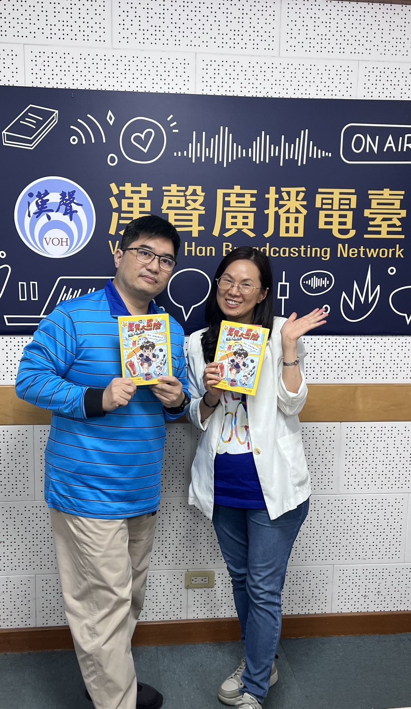 錄音室合照，嚴淑女與Simon手持《莫非大冒險1：日常的魔咒》一書