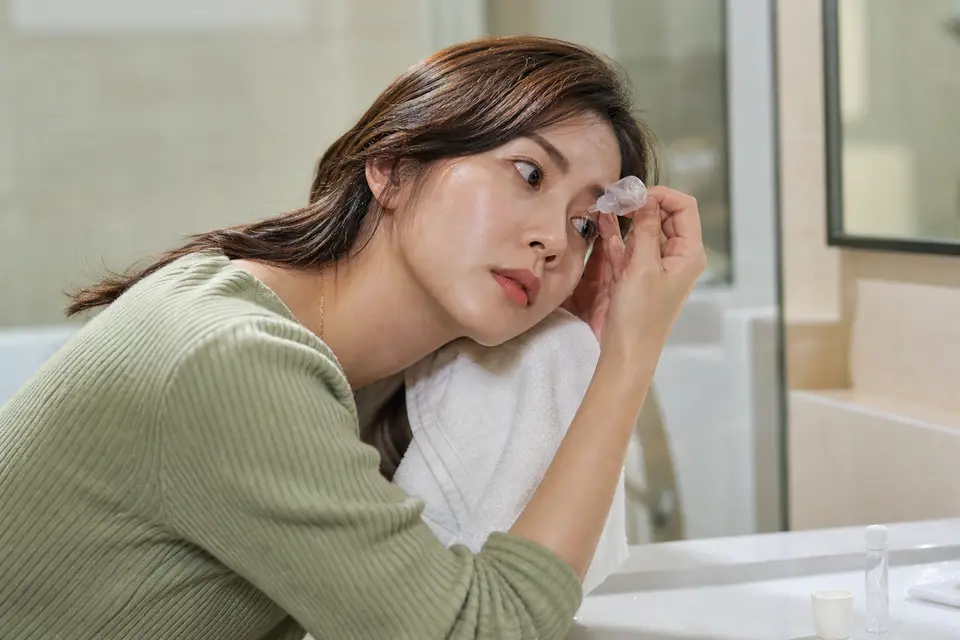 特寫一個人用生理食鹽水沖洗眼睛,示意正確的沖洗方向
