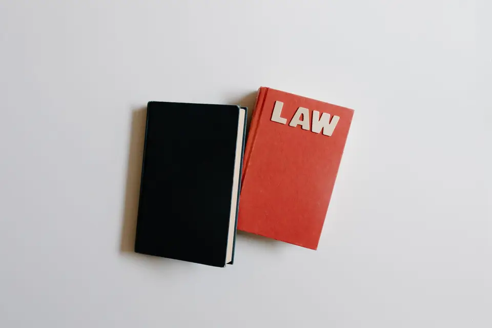 法律書籍、眼鏡與筆記放在桌上，呈現閱讀法律扶助服務說明的情境