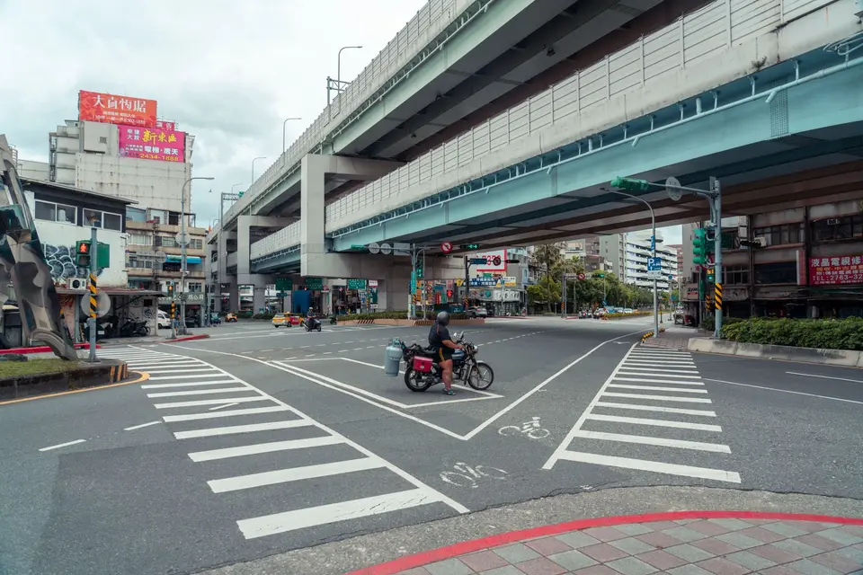 城市路口可見白色車道標線與轉彎動線，車輛依路型通過