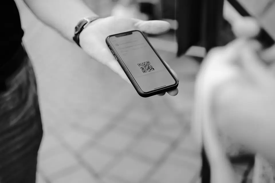 手機在旅行文件旁顯示 QR code，呈現完成 Visit Japan Web 電子申報後保存資料的情境