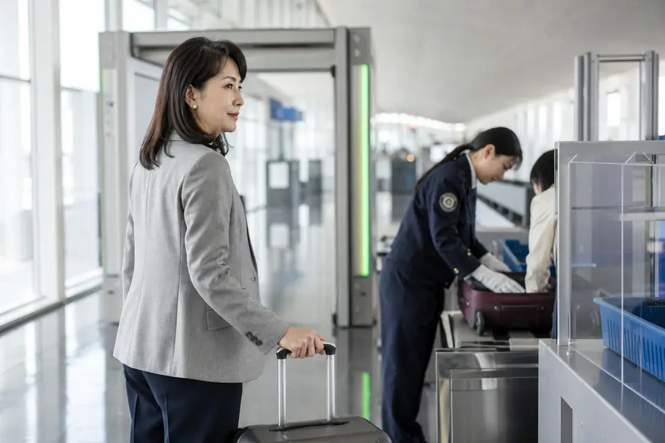 機場檢查區的旅客與行李通過電子閘口，呈現海關申報後可能接受檢查的情境