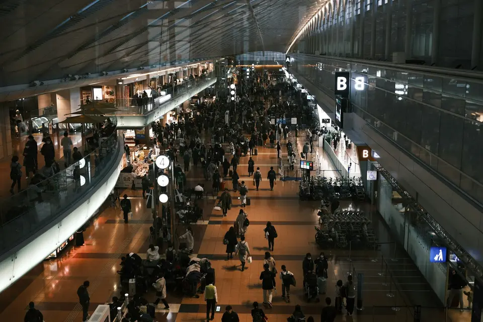 日本機場航廈內旅客與行李動線，呈現完成入境手續後前往出口的場景