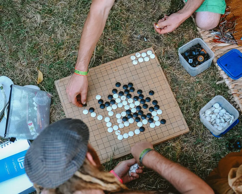 兒童在桌邊對弈，棋盤上擺著黑白棋子